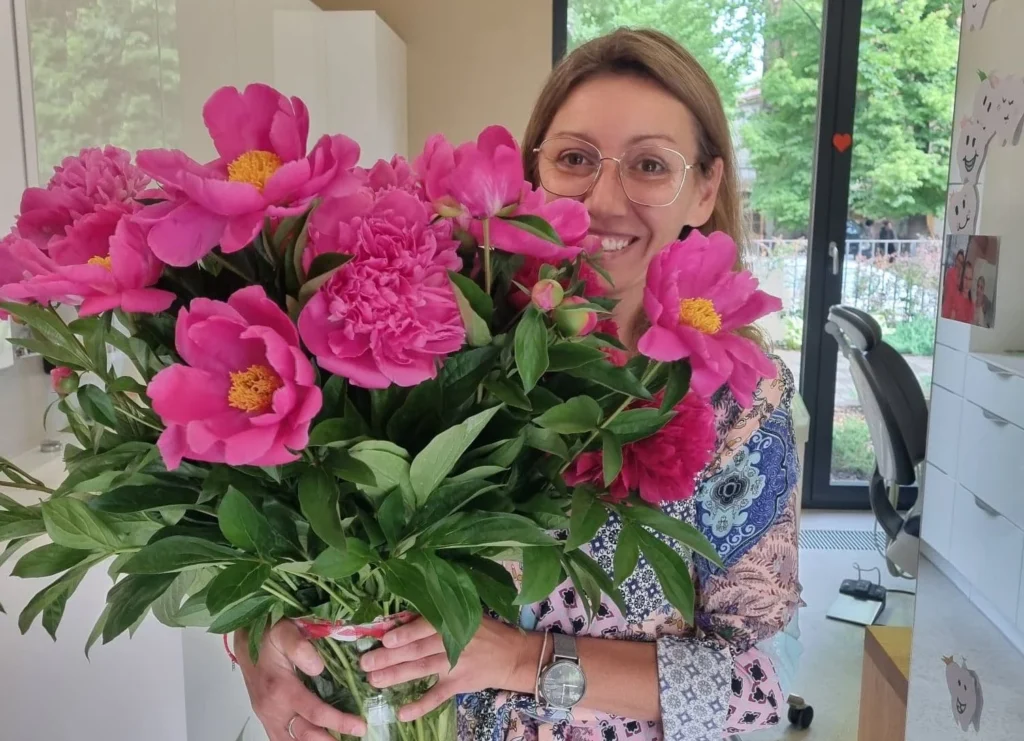 Zdjęcie przedstawia Doktor Agnieszkę Książek z bukietem kwiatów