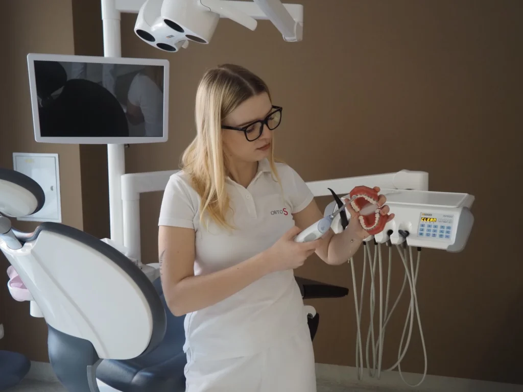 Zdjęcie przedstawia higienistkę Maję, która pokazuje jak dbać o higienę jamy ustnej