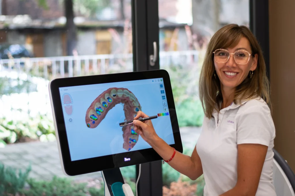 Zdjęcie przedstawia Doktor Agnieszkę Książek pracującą przy urządzeniu iTero